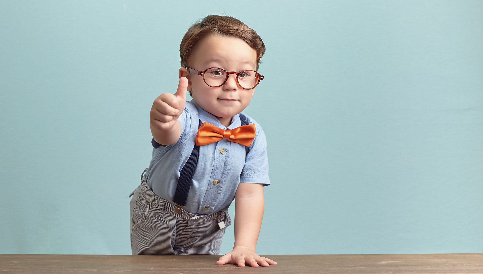 Portrait of happy little boy giving you thumbs up